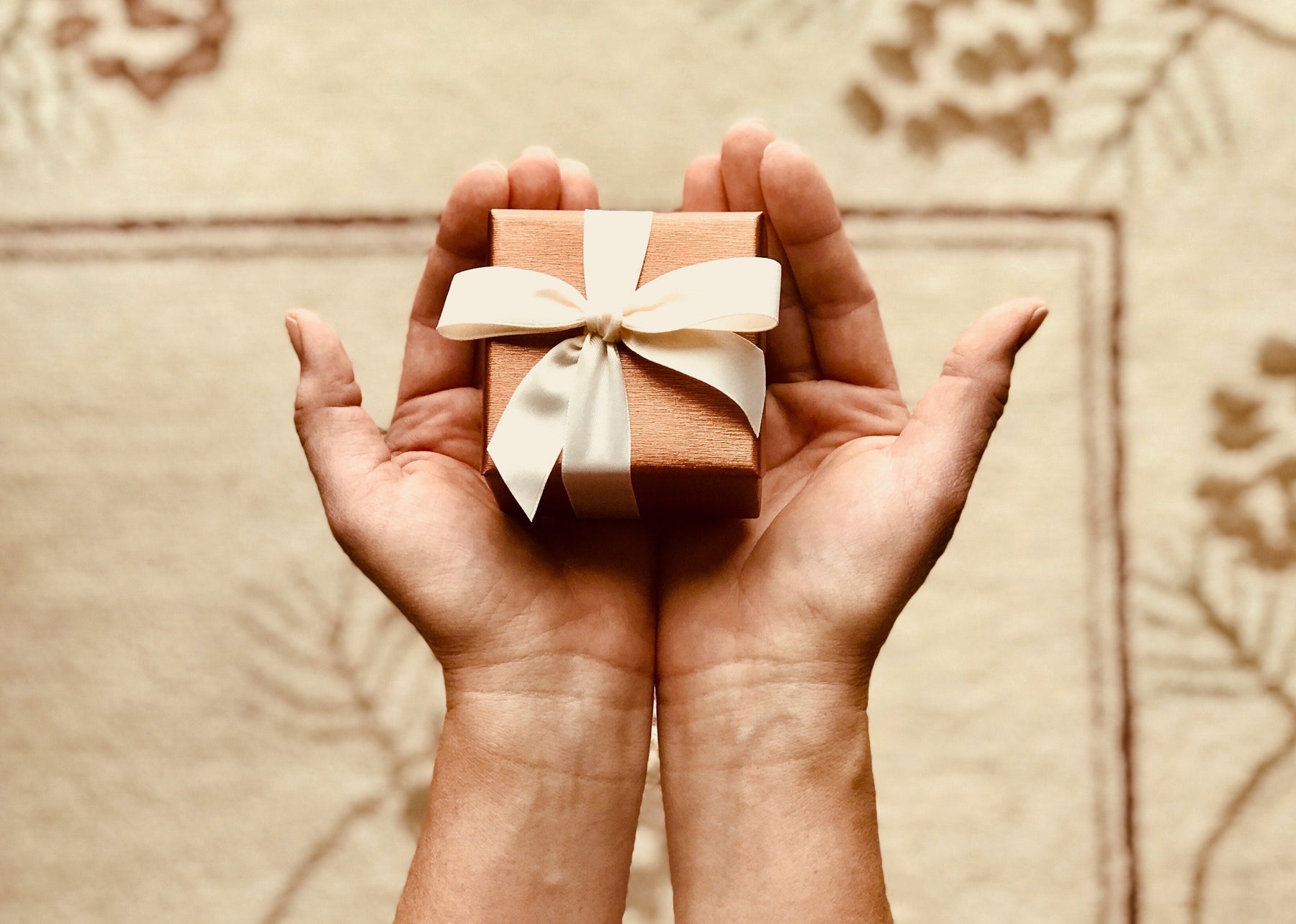 gift box in palms; ribbons; surprise birthday gift; gift ideas; gift guide; surprise gift box; aromatherapy gifts