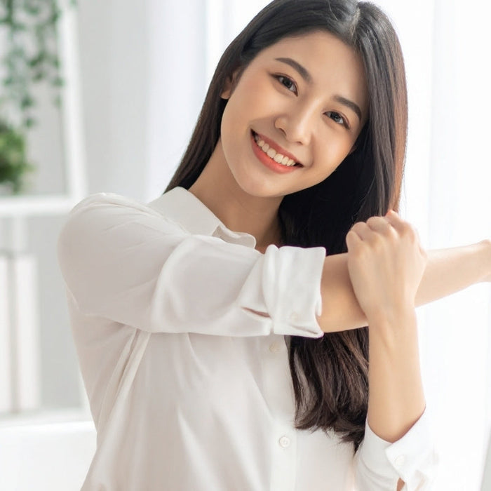 Asian Woman Stretching at Desk in Office Photgraph