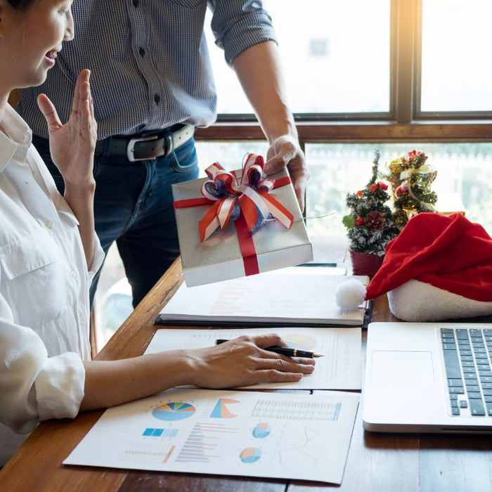 colleague giving christmas gift in the office