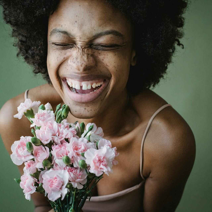 Thoughtful get well soon gifts to send in Singapore; woman with pink flower bouquet