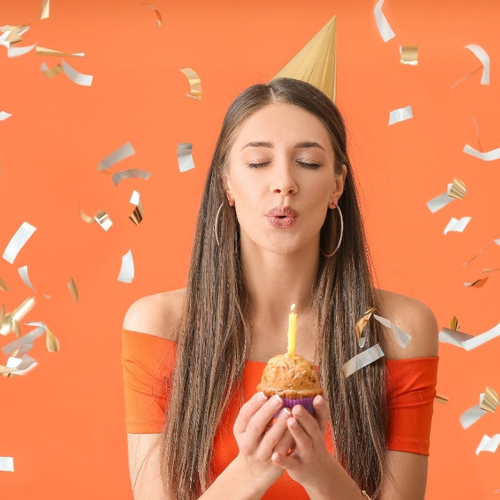 Young Woman Celebrating Birthday on Color Background