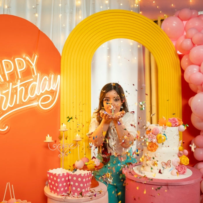 birthday celebrant Throwing Confetti between Birthday Decorations 