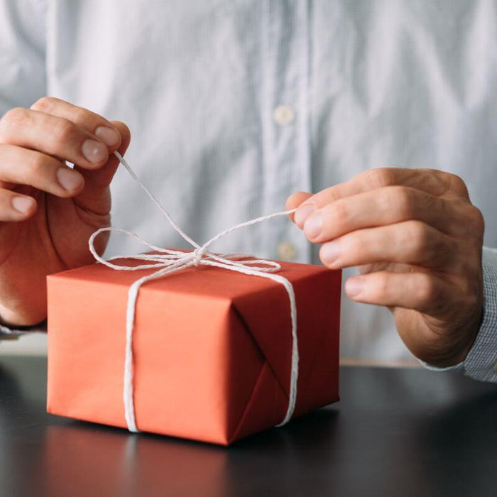 businessman opening a gift from a corporate gift supplier
