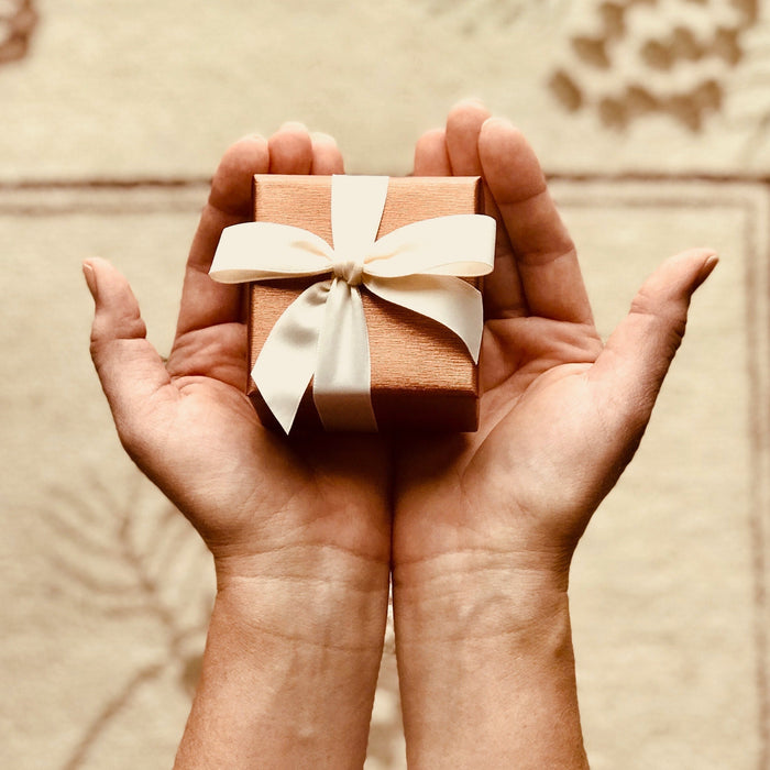 gift box in palms; ribbons; surprise birthday gift; gift ideas; gift guide; surprise gift box; aromatherapy gifts