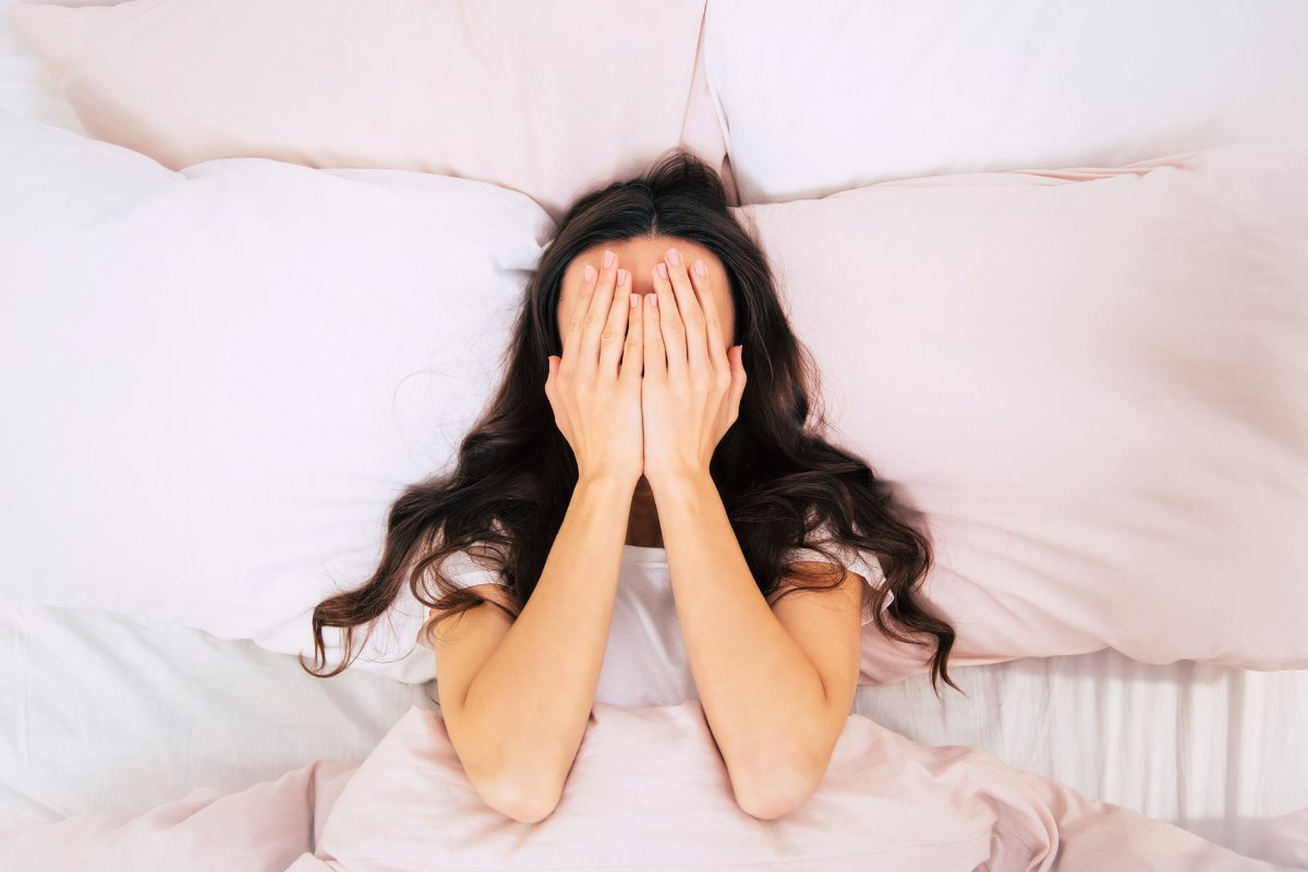 woman on bed with sleep deprivation